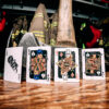 Bicycle Firefighters Playing Cards Court Cards on a wooden table inside of a fire station. Fire gear can be seen blurred in the background.