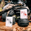 Bicycle Firefighters Playing Cards Jokers on a wooden table on the boots of turnout gear inside of a fire station. Fire gear can be seen blurred in the background.